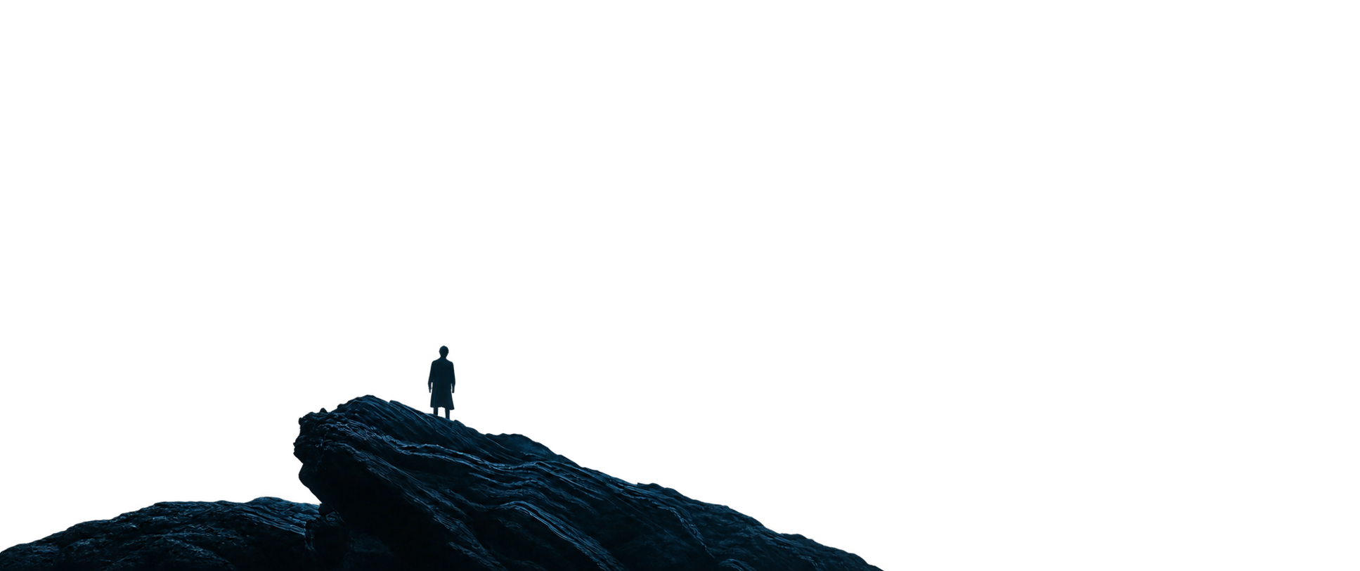 A lone figure stands on a rocky ledge, gazing at the sky